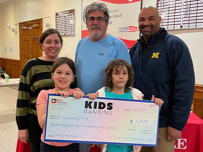 KIDS Banking members at their school get a check for membership goals reached.